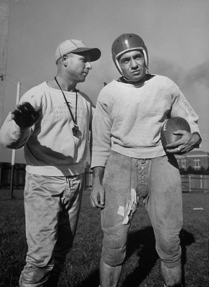 Ohio State's Paul Sarringhaus gets instruction from a coach, 1941.