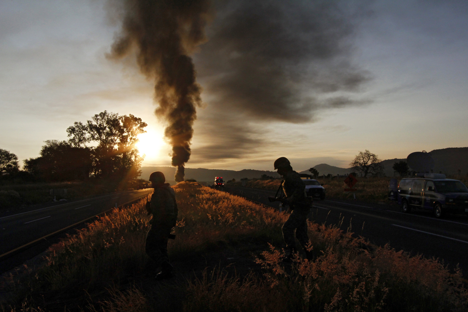 Image: Oct. 19, 2012. Mexican soldiers are backlit after a gas pipeline explosion in Zapotlanejo, Mexico.