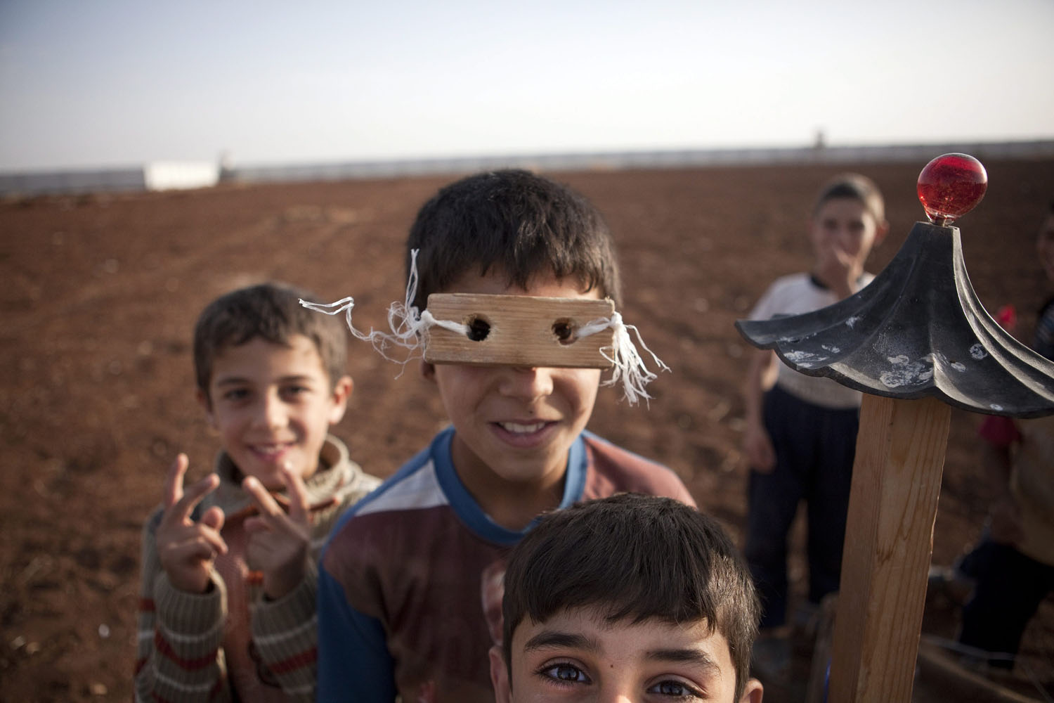 Oct. 7, 2012. Syrian refugee children play with materials they find, such as a piece of wood turned into glasses, in a camp at the Syrian-Turkish border near Azaz, Syria. The makeshift refugee camp is reported to be growing daily.