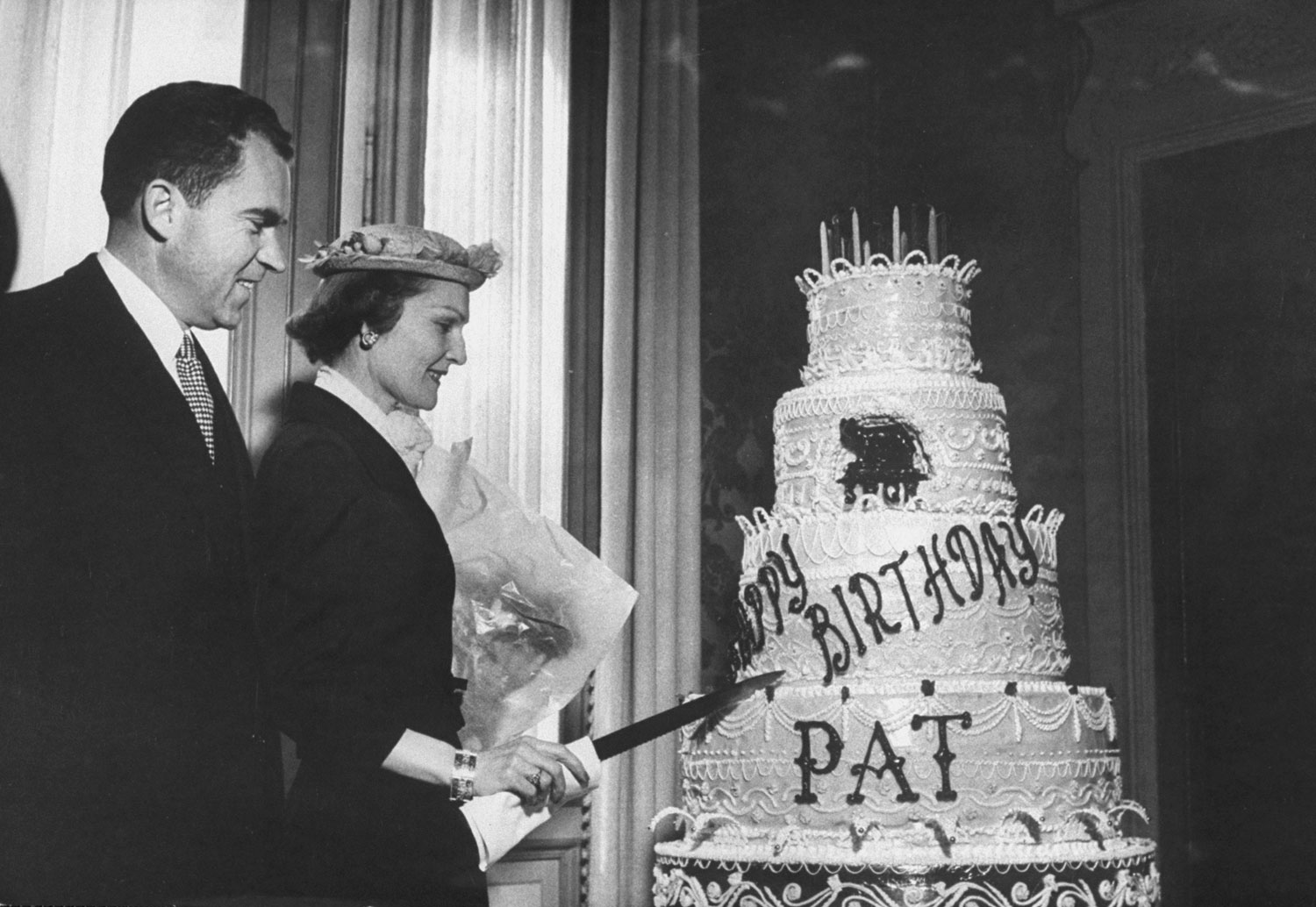 Vice President Richard Nixon watches his wife and future First Lady Pat cut her birthday cake, 1957.