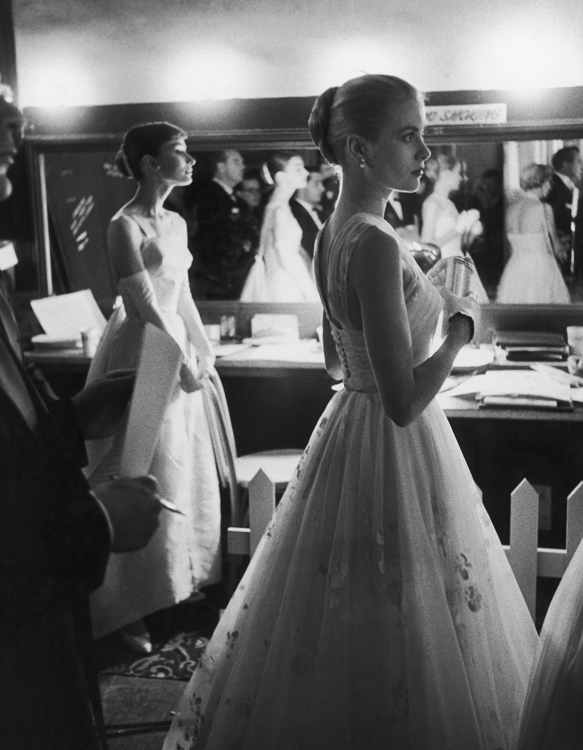 Audrey Hepburn and Grace Kelly wait backstage at the RKO Pantages Theatre during the 28th Annual Academy Awards, 1956.