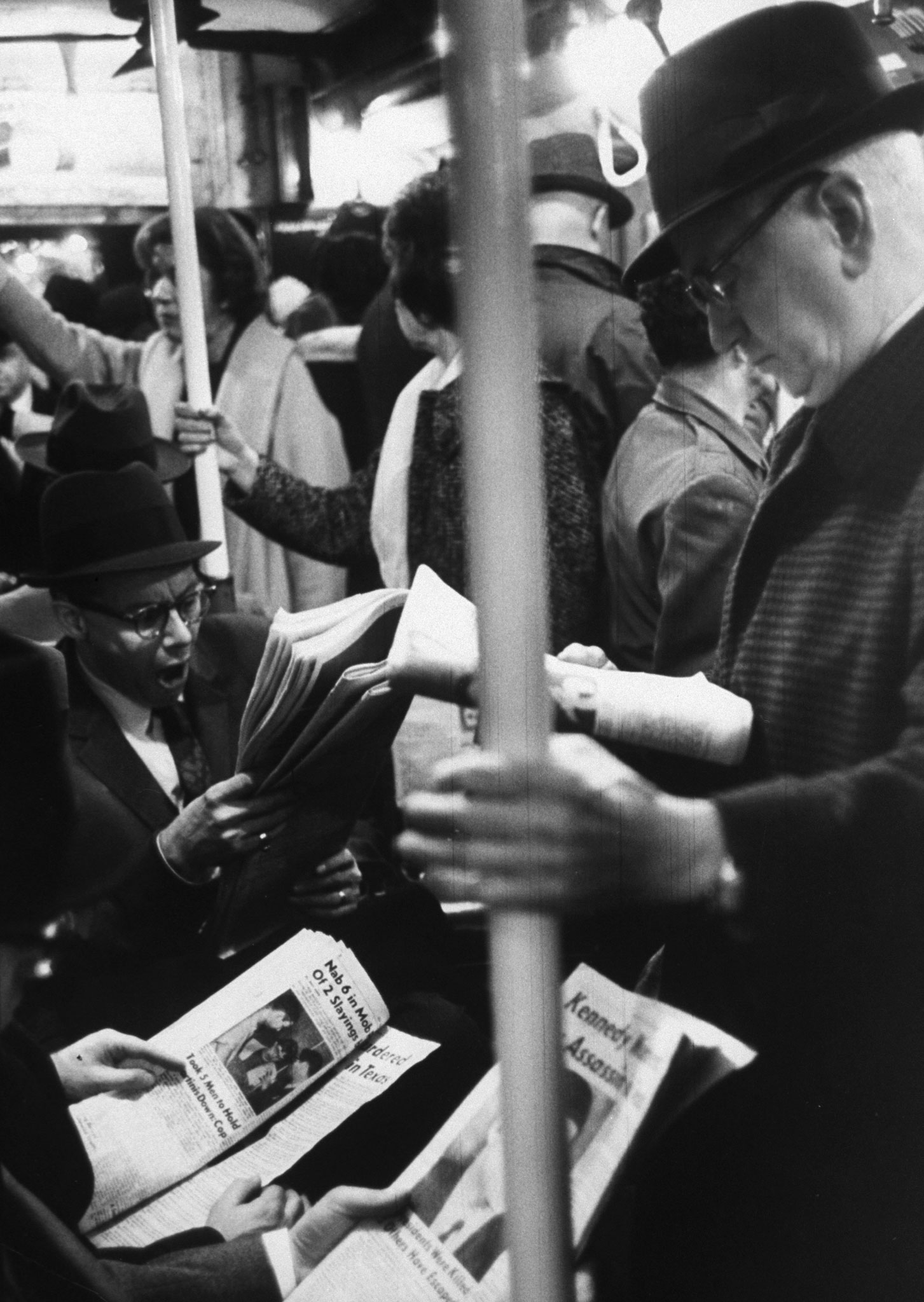 Commuters reading of John F. Kennedy's assassination on the New York subway, November 1963.