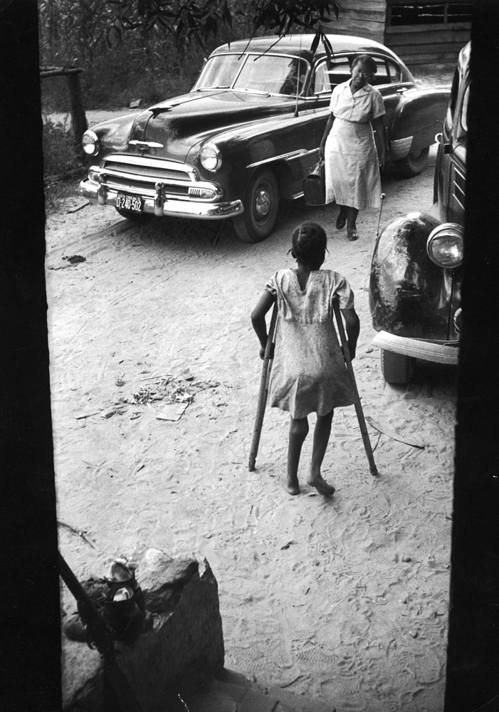 Caption from LIFE. Crippled girl greets Maude at her door. ...