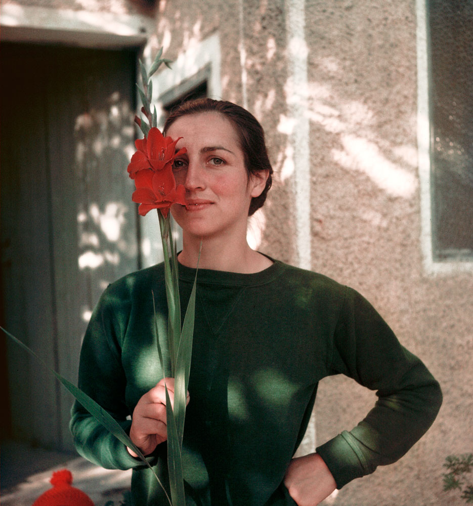 Picasso's one-time muse, the artist Françoise Gilot, poses with a red gladiola, France, 1949.