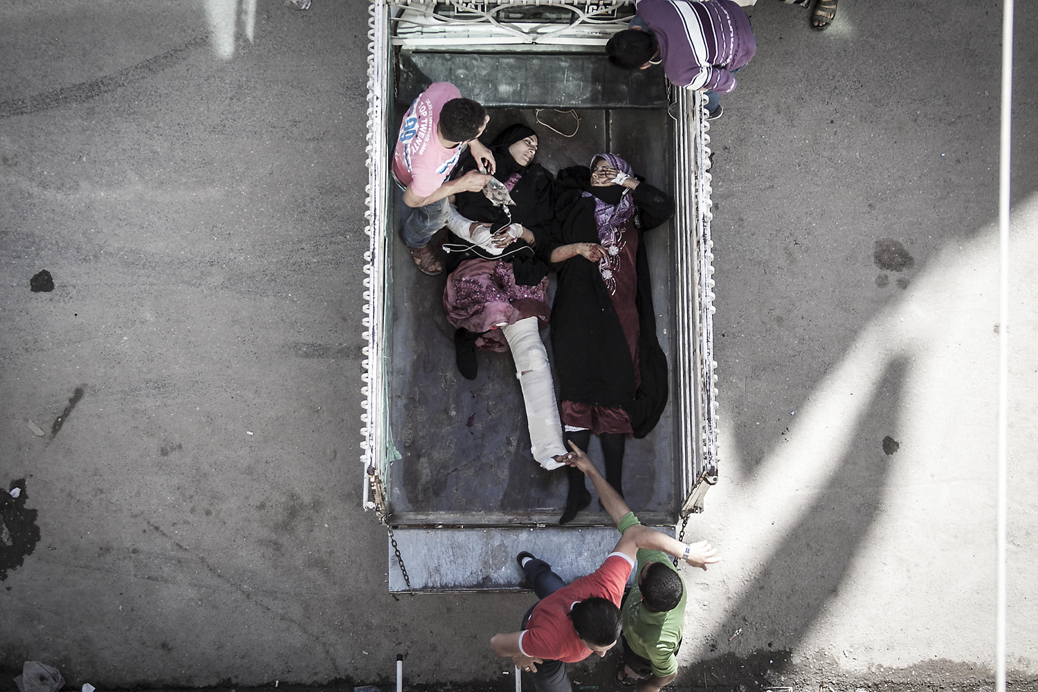 Image: Oct. 21, 2012. Women civilians lay in the back of a truck as they are removed from a hospital in the Tarik Al Bab neighborhood, after they were injured by aircraft strike on a highway in Aleppo, Syria.