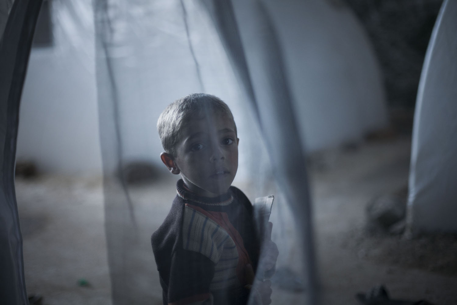 Oct. 7, 2012. A Syrian boy, who fled his home with his family due to fighting between government forces and rebels, stands near his tent at a refugee camp near the Turkish border in Azaz, Syria.