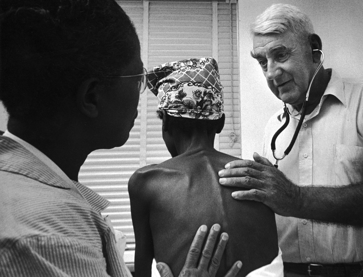 Caption from LIFE. Dr. W. K. Fishburne, head of the Berkeley County health department, examines a patient brought to hospital by Maude.