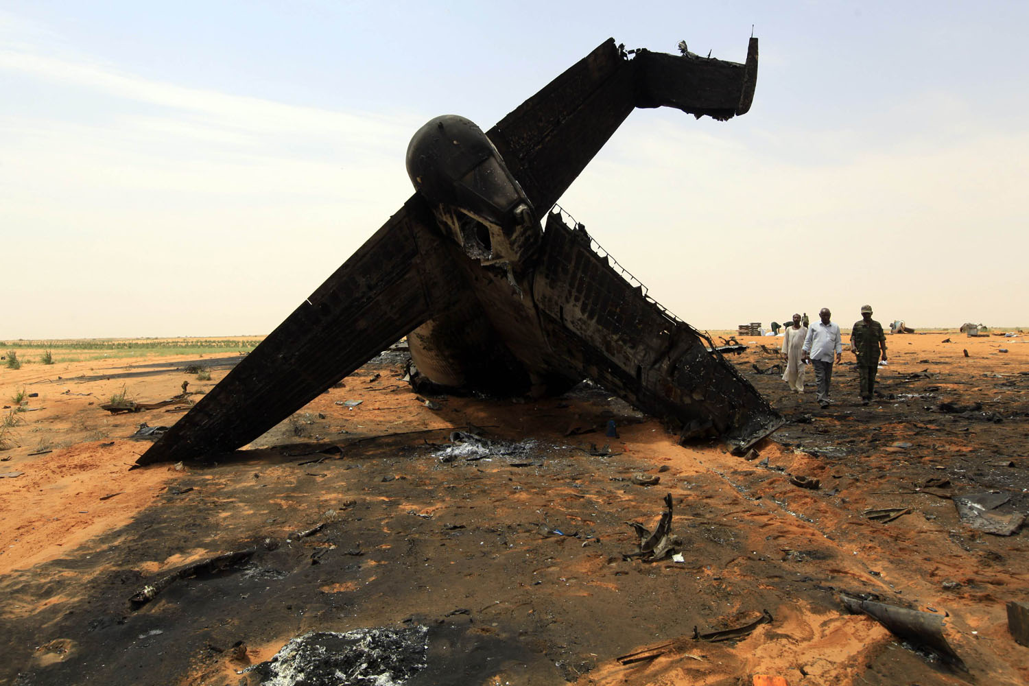Oct. 8, 2012. Rescue workers walk through the remains of a Sudanese military plane after it crashed at the North Korodofan State border near the capital Khartoum.