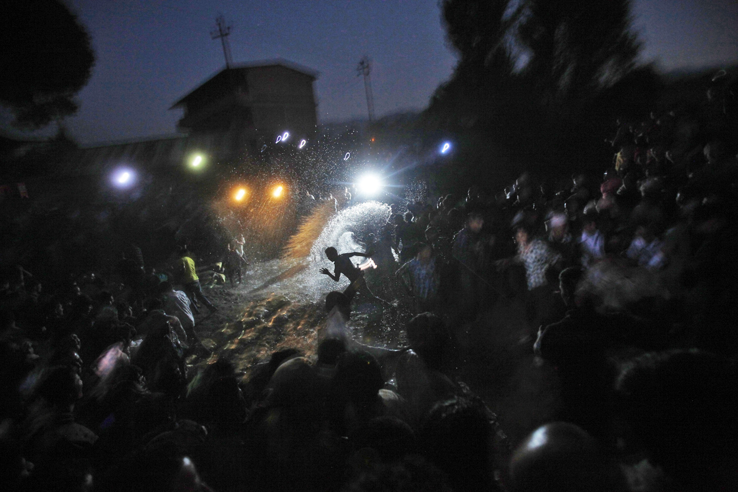 Image: Oct. 23, 2012. Nepalese devotees splash water on a water buffalo, unseen, as part of a ritual before sacrificing it, during the ninth day of the Dashain festival in Katmandu.