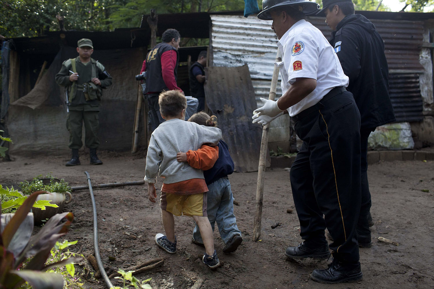 Oct. 9, 2012. Carlos Daniel Gonzalez (L), 6, holds his sister Izabel, 4, as they are accompanied by authorities after unknown gunmen killed their parents and other relatives in the municipality of Villa Canales, 22 kilometers from Guatemala City.