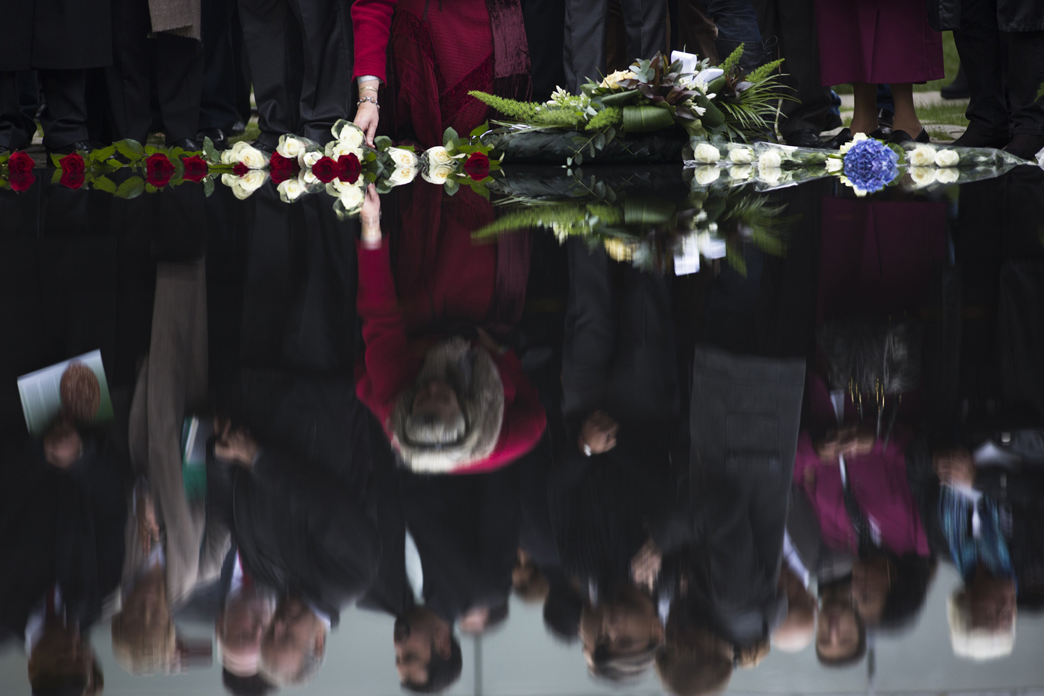 Image: Oct. 24, 2012. People lay flowers during the inauguration of the "Memorial to the Sinti and Roma of Europe Murdered under National Socialism" in Berlin.
