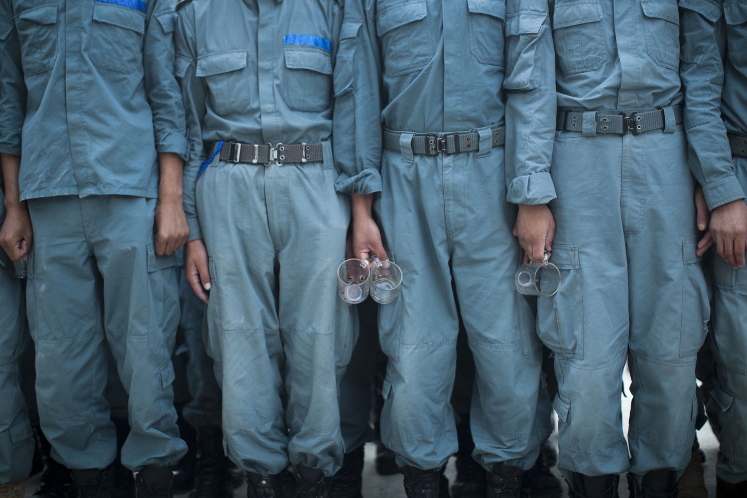 Oct. 9, 2012. Afghan National Police officers line up with their tea glasses before breakfast at the Police Academy in Kabul.