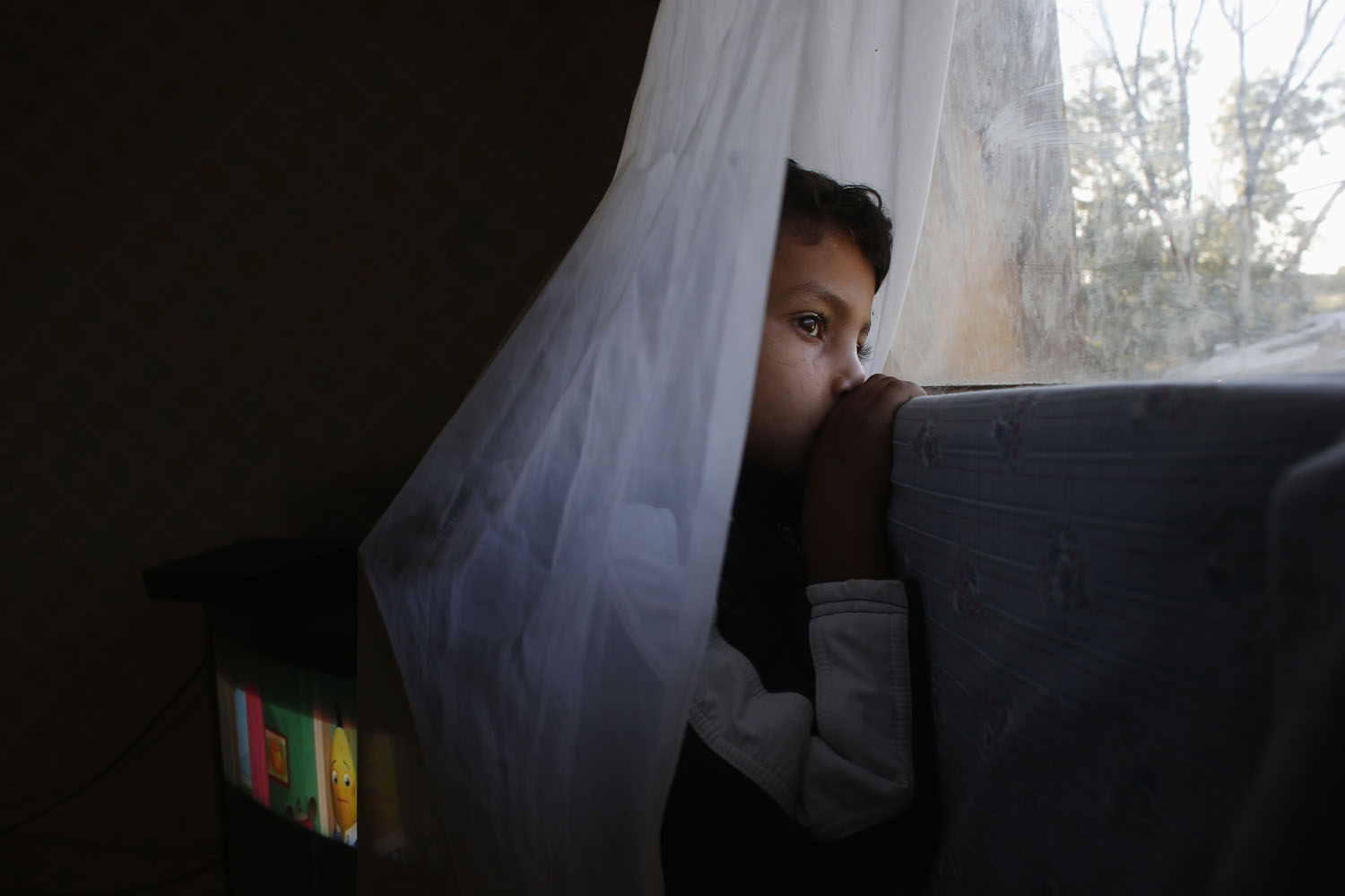 Oct. 9, 2012. 6-year-old Abel watches from his window as an excavator demolishes a neighbor's shack in the shantytown settlement of  El Gallinero  on the outskirts of Madrid. A handful of shacks were torn down under the orders of Madrid's town planning board.