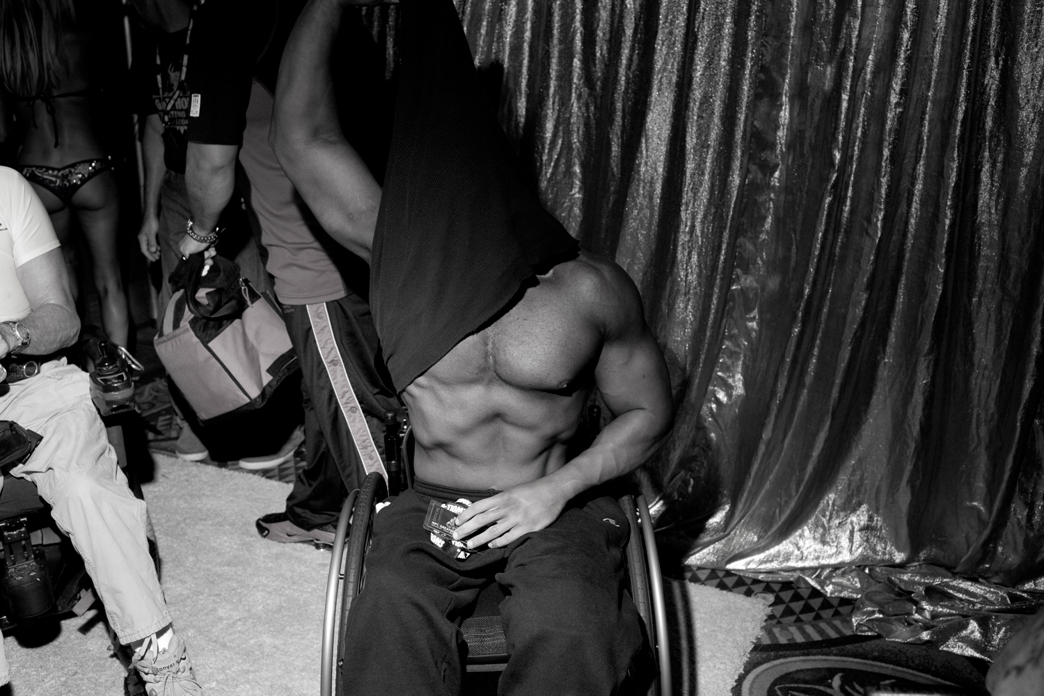 Roger Espina removes his shirt backstage in Metairie, La. Espina credits his interest in bodybuilding to a family friend who gave him a book about Arnold Schwarzenegger.