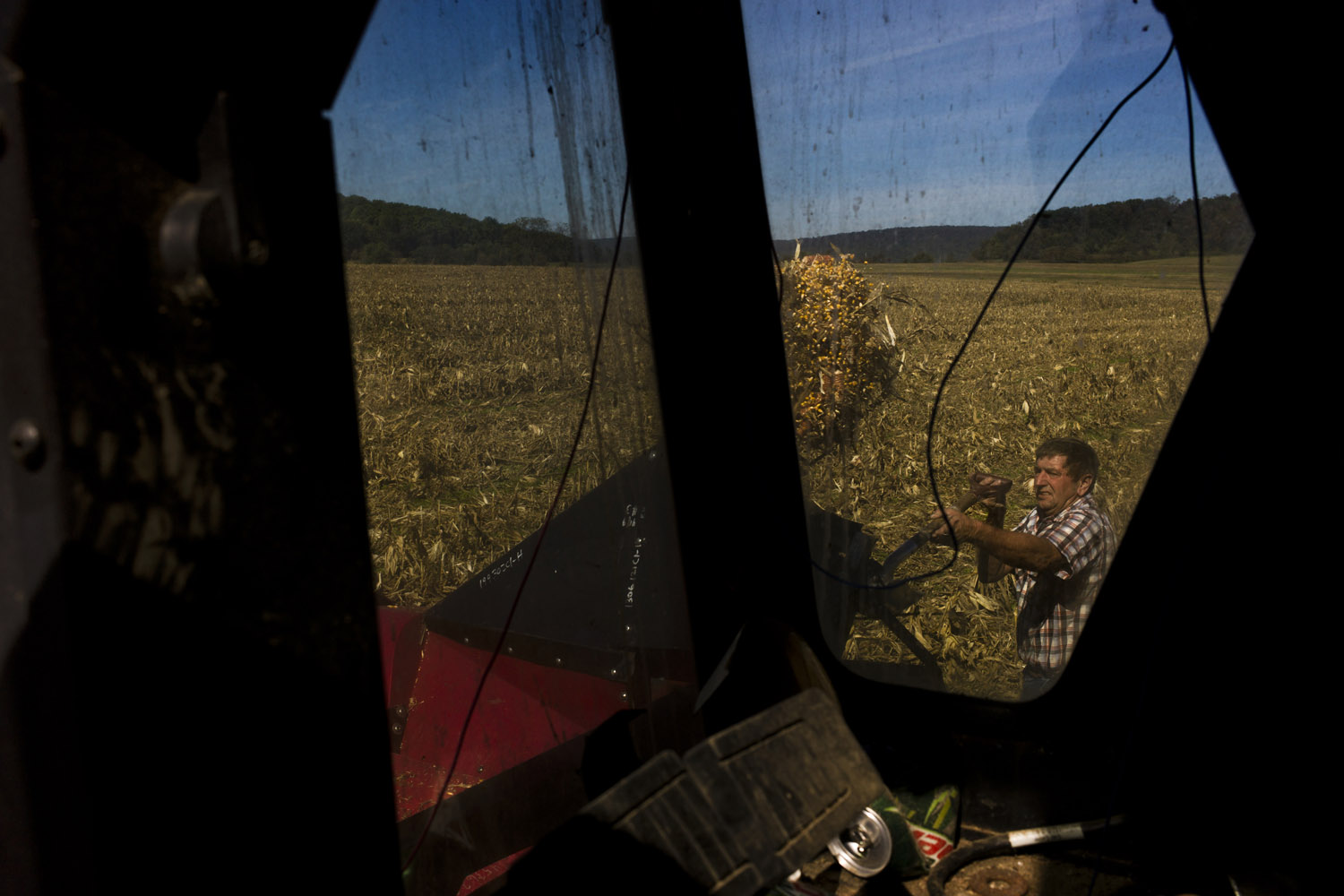 Image: A farmer shuffles spilled corn into his combine on a farm near Redding. He plans to vote for Romney, because he is 'tired of the lies.' Oct. 1, 2012.