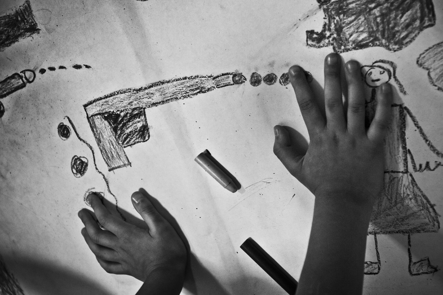 A child draws daily scenes of violence in his community. The age of entry into crime life is dropping and there are an increasing number of cases involving boys as young as 10 or 11 years old.
