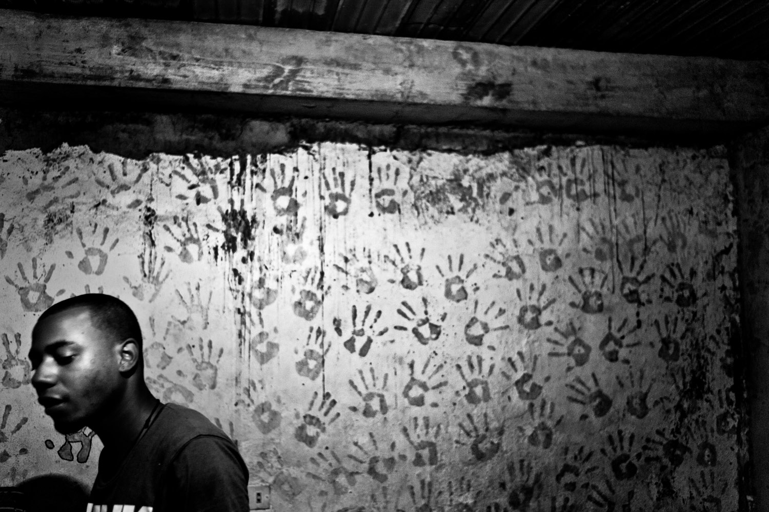 A hip hop artist plays music at his home for members of a local gang. The hand prints on the wall served as a popular symbol for Chavez in the 2006 presidential elections, representing the 10 million votes his supporters said he would obtain.