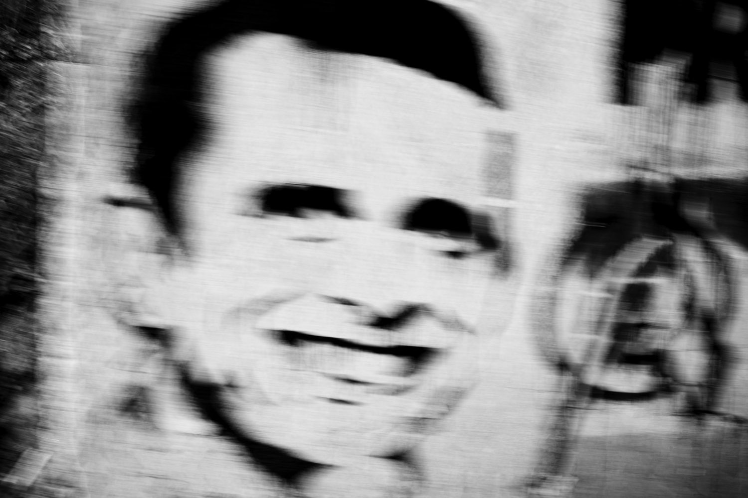 image: A stencil depicting Henrique Capriles Radonski, the presidential candidate for the opposition party. Political graffiti covers much of the city, serving as a constant reminder of the nation's political tensions.
