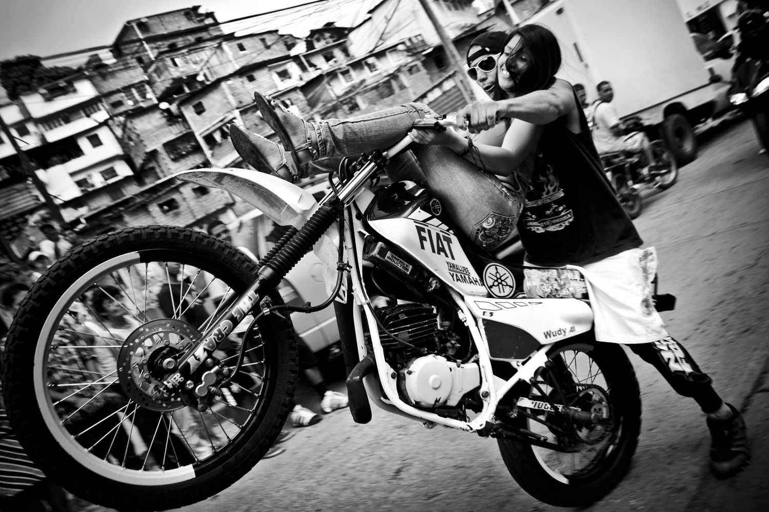 image: Motorcycle stunts in Caracas. Motorcycle, like cellphones, are some of the most coveted objects in the city, and the source of a number of conflicts in the city.