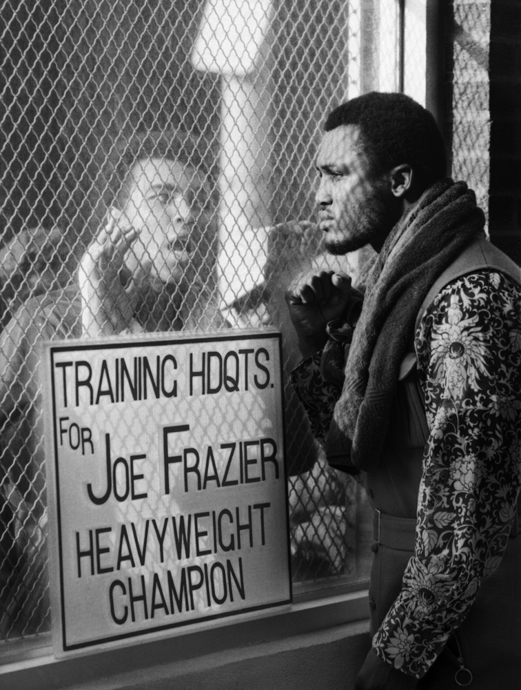 Muhammad Ali (left) taunts rival and heavyweight champ Joe Frazier at Frazier's training camp ahead of their March 1971 "Fight of the Century" title bout.