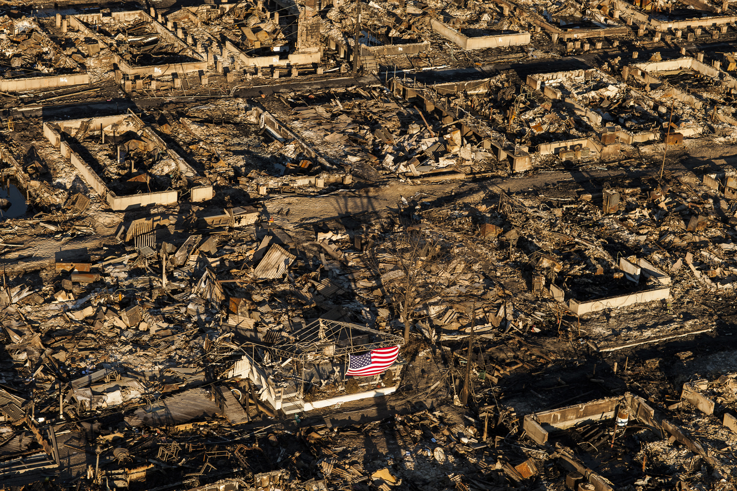 Image: Nov. 3, 2012. An American flag in a burned out area of Breezy Point, Queens, N.Y. More than 80 homes were destroyed by wind-fed fire during hurricane Sandy.