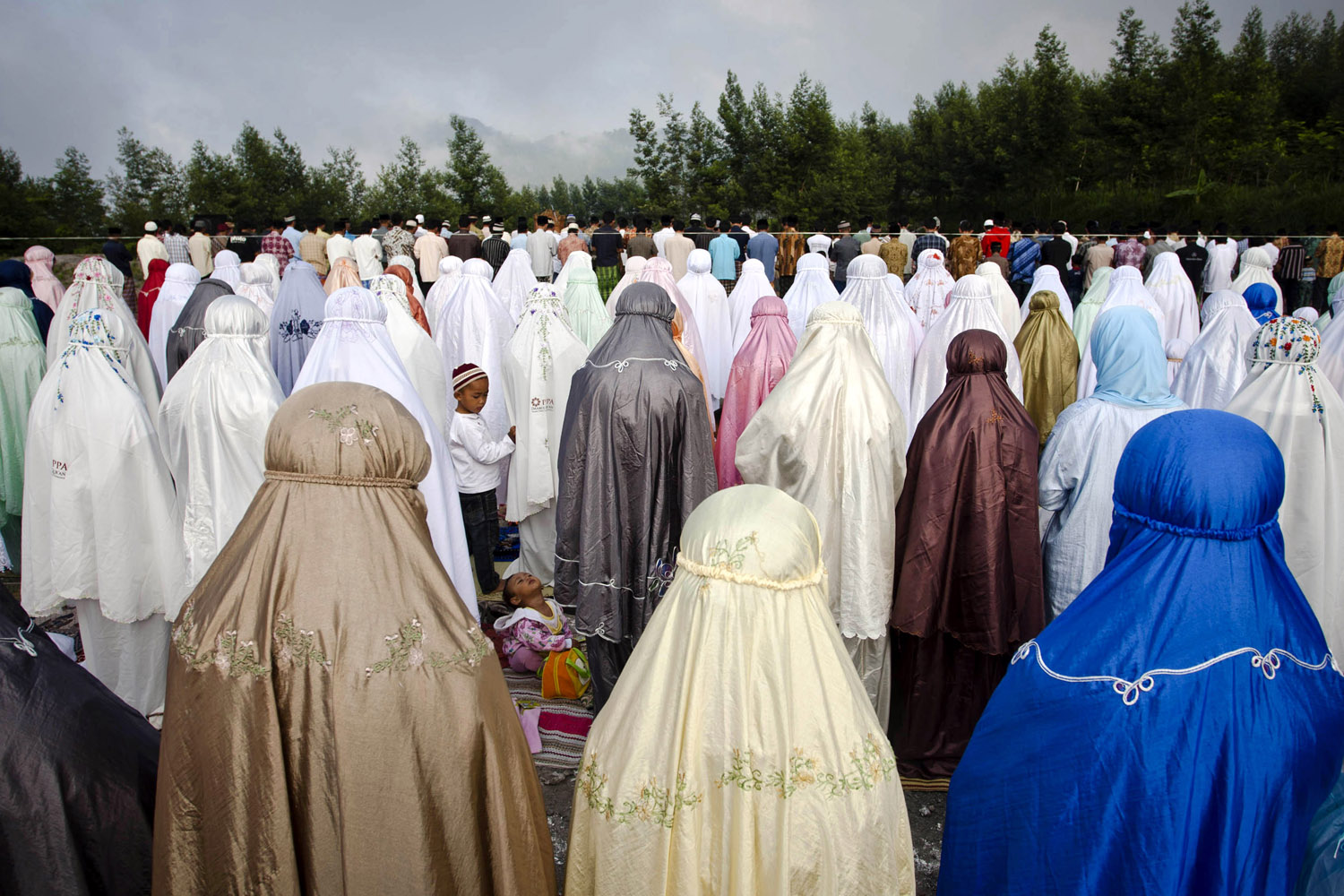 Image: Oct. 26, 2012. Indonesian Muslim women attend prayer at the slopes of Mount Merapi during celebrations for Eid al-Adha, the 'Festival of Sacrifice', at Kalitengah Lor village in Yogyakarta, Indonesia.