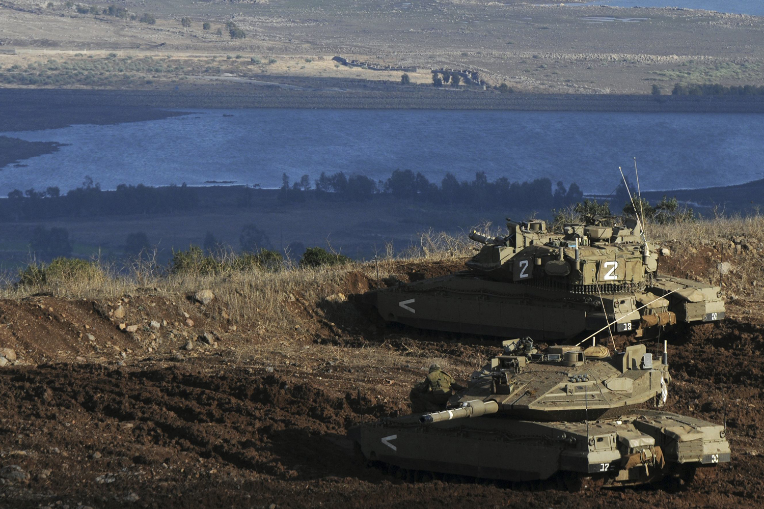 Image: Nov. 12, 2012. Israeli tanks stand in position overlooking a Syrian village from the Israeli-occupied Golan Heights.