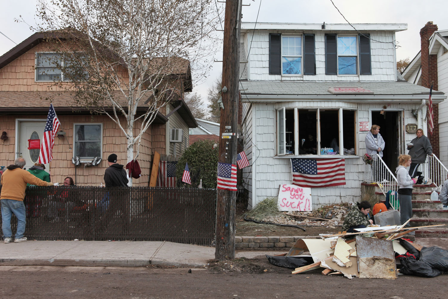 Neighbors and their families living on Cedar Grove Avenue, the block closest to Cedar Grove Beach in New Dorp, take a break from removing debris from their homes six days after Superstorm Sandy.