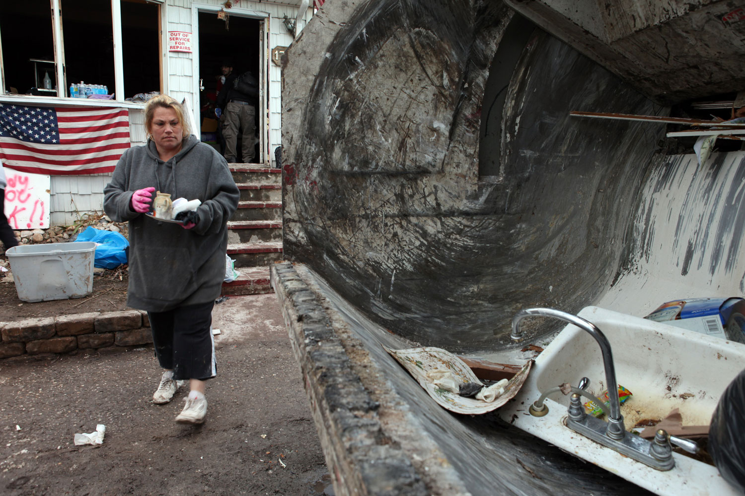 Jackie Oefelein, who lives on Cedar Grove Avenue, throws the last bit of debris from her house into a garbage truck.