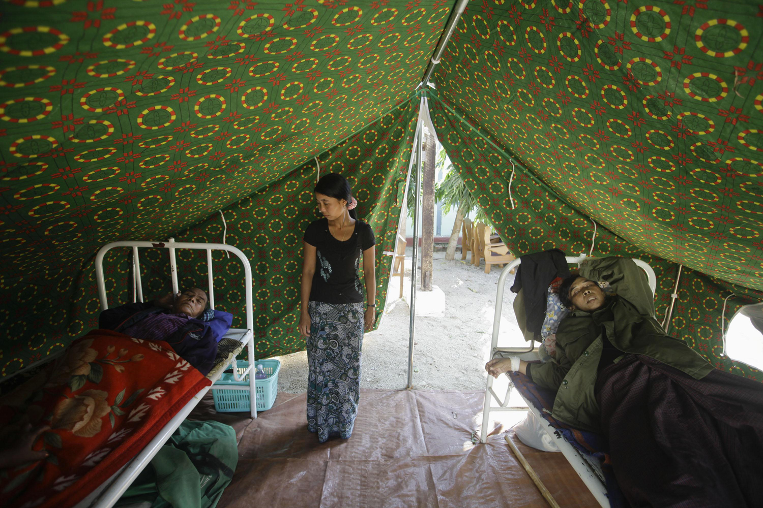 Image: Nov. 12, 2012. Injured people are treated outside a damaged hospital in Thabeik Kyin township, Myanmar.