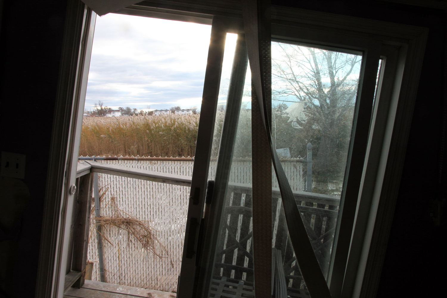 The marsh is visible through the window of Eddie Alvarez's house in Oakwood. The back of the house was lifted from its foundation and thrown sideways by the surge during the storm. Eddie, his wife, two dogs and a bird rode out the storm in the attic until they were rescued in the early morning by six firefighters.