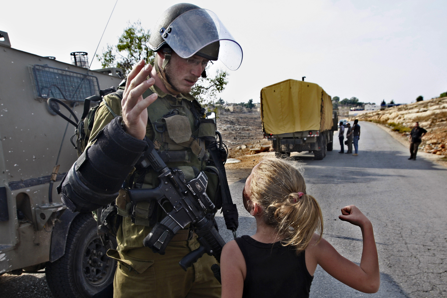 Image: Nov. 2, 2012. A Palestinian girl tries to punch an Israeli soldier during a protest against the expansion of the nearby Jewish settlement of Halamish, in the West Bank village of Nabi Saleh near Ramallah.