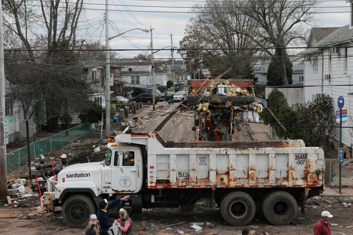 The New York Sanitation Department clears away debris from residents’ homes on Garibaldi Avenue, a block from Cedar Grove Beach in New Dorp.