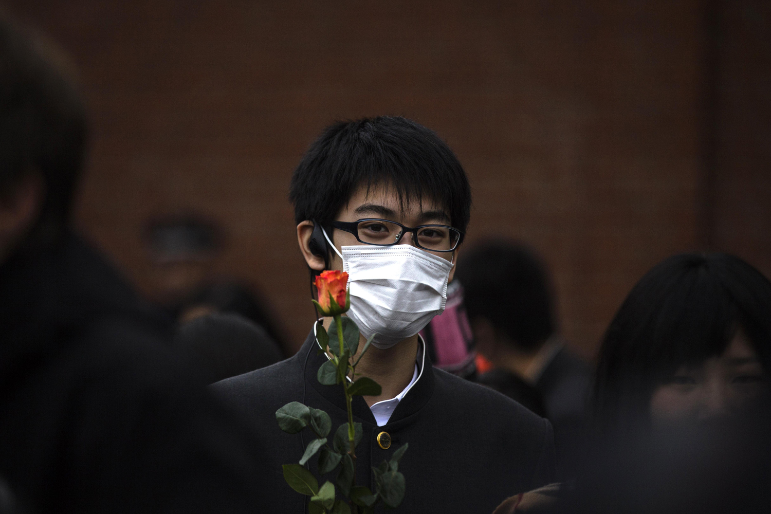 Image: Nov. 9, 2012. A Japanese high school student holds a rose as he attends a ceremony to remember the fall of the Berlin Wall 23 years ago at the memorial site Bernauer Strasse in Berlin.