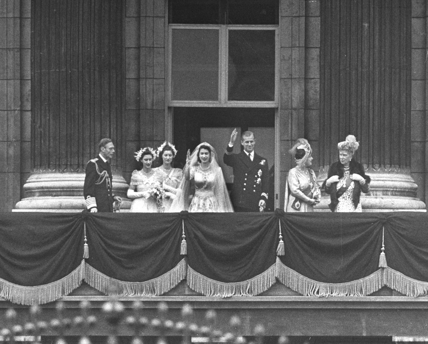Royals on the balcony of Buckingham Palace: (l. to r.) King George VI, Princess Margaret Rose, unidentified, Princess Elizabeth, Prince Philip, Queen Elizabeth and Queen Mother Mary after wedding of Elizabeth and Philip.