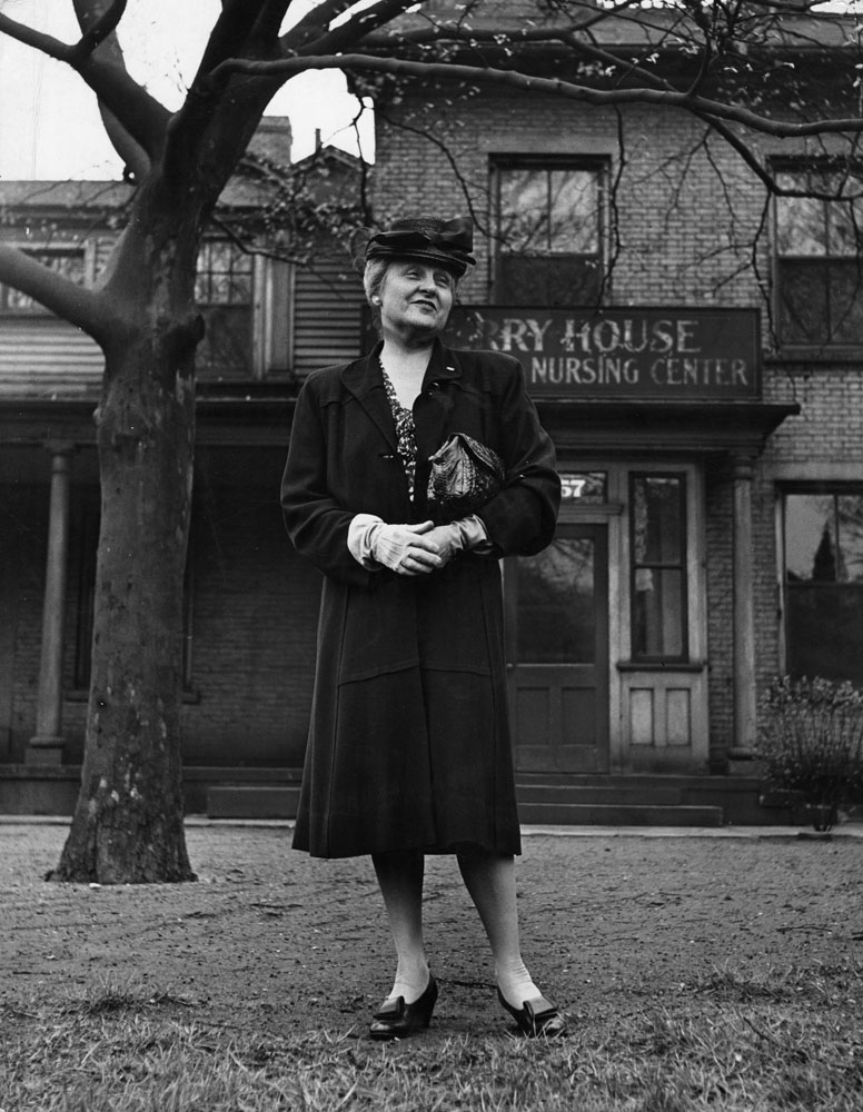 Republican congresswoman Mrs. Chester C. Bolton, Ohio's first and (at the time) only woman representative, stands in front of her great grandfather's Euclid Avenue mansion, Cleveland, Ohio, 1944.