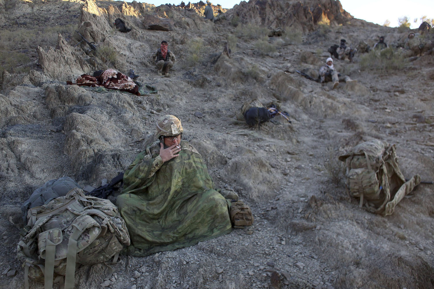 Image: Nov. 2, 2012. U.S. and Afghan soldiers rest during an operation on a cold morning near the town of Walli Was in Paktika province.