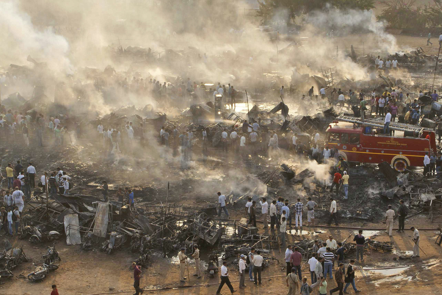 Image: Nov. 10, 2012. People gather at the site of a firecracker market that was destroyed in a fire in Vadodara, India.