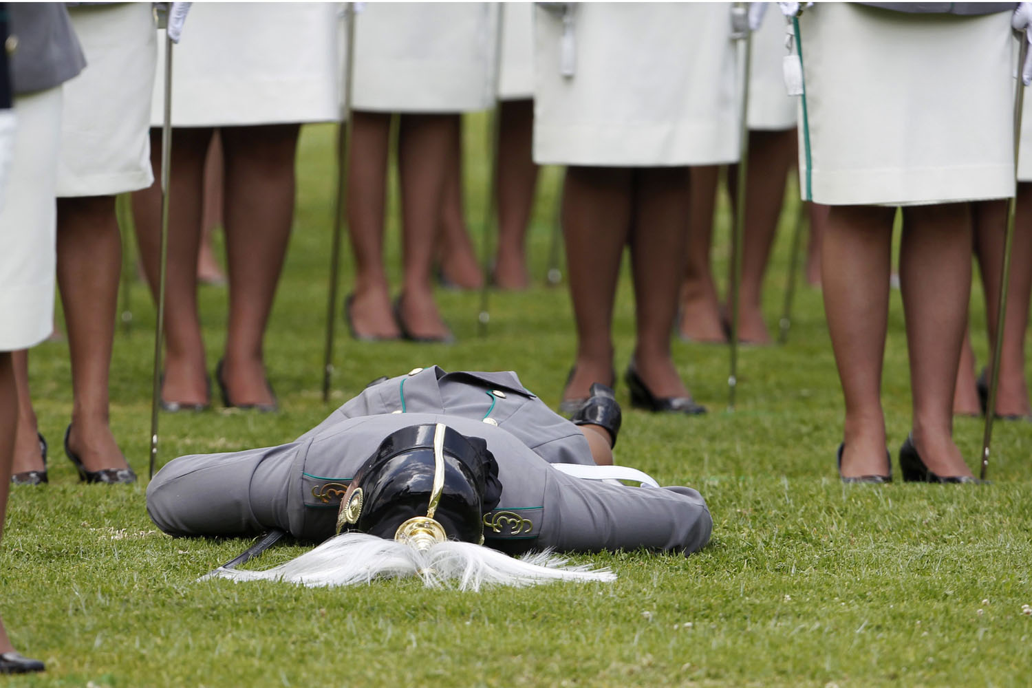 Image: Nov. 2, 2012. A cadet lies on the grass after collapsing during an annual ceremony for graduating cadets at the police school in Bogota.