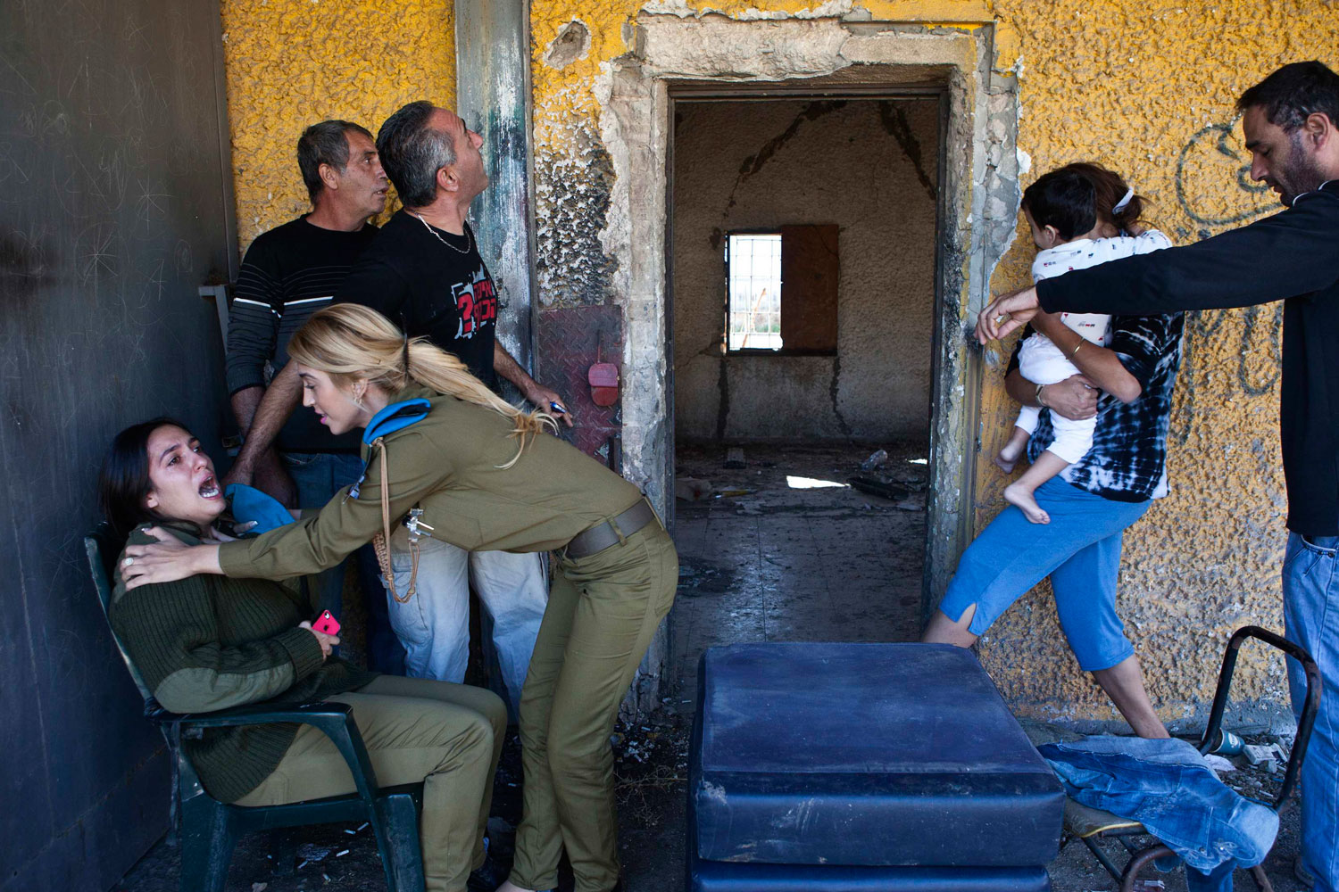 Image: Nov. 15, 2012. Israelis react and run for cover as a siren sounds a warning of incoming rockets in the southern town of Kiryat Malachi.