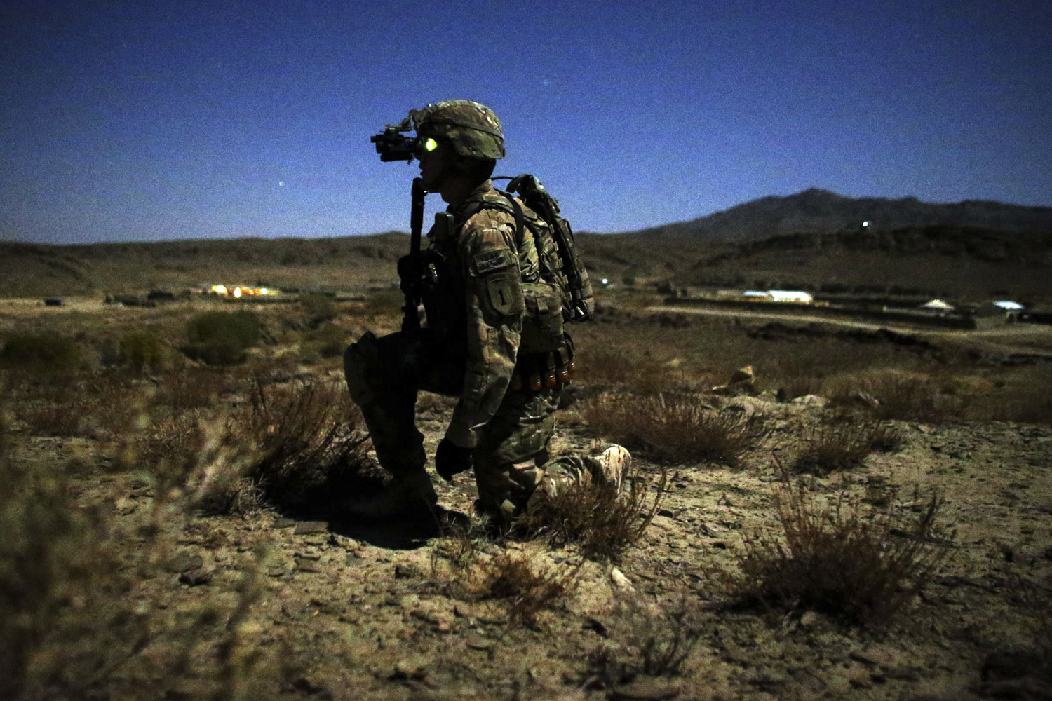 Image: Oct. 28, 2012. A U.S. soldier kneels during a night foot patrol near COP (Combat outpost) Sar Howza in Paktika province, Afghanistan.