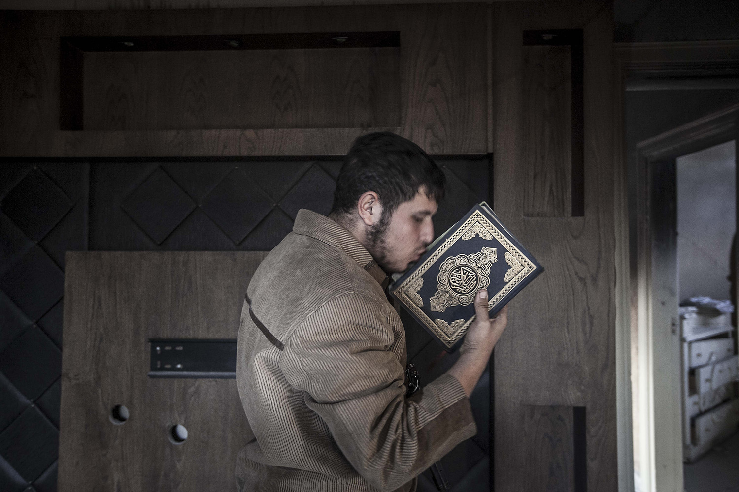 Image: Oct. 28, 2012. A rebel fighter belonging to the Liwa Al-Tawhid group, kisses a Quran as mortar explosions and gunshots are heard in the nearby battlefield in the Karm al-Jabel neighborhood of Aleppo, Syria.
