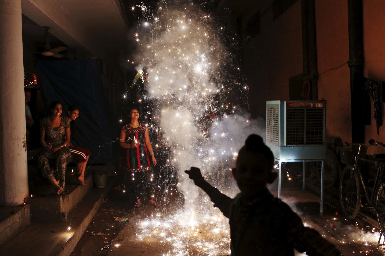 Image: Nov. 13, 2012. An Indian family lights firecrackers during the festival of Diwali in New Delhi.