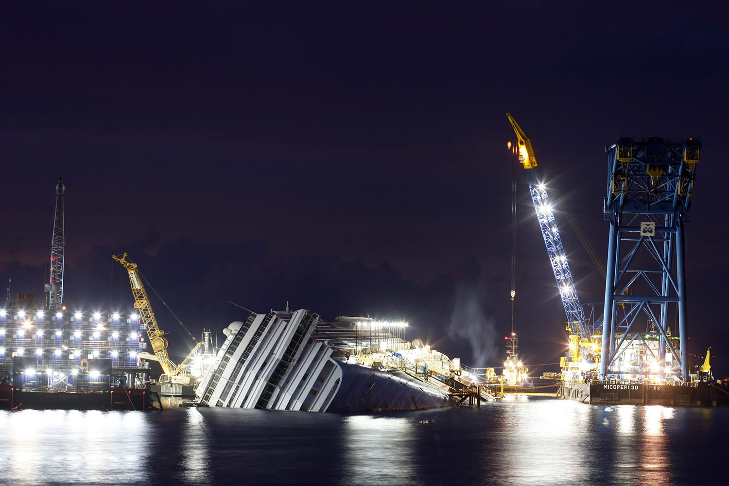 Image: Nov. 6, 2012. The capsized cruise liner Costa Concordia is seen surrounded by cranes during a rescue operation in front of Giglio harbour.
