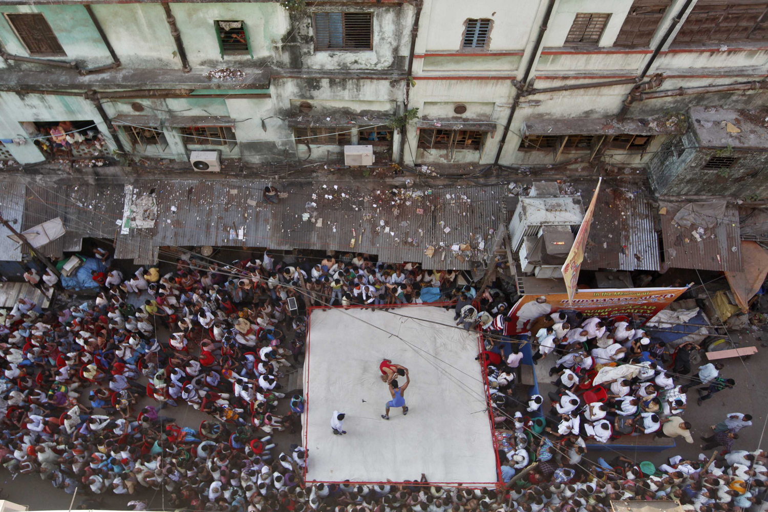 Image: Nov. 14, 2012. Two wrestlers fight during an amateur wrestling match inside a makeshift ring built on a road junction in Kolkata.