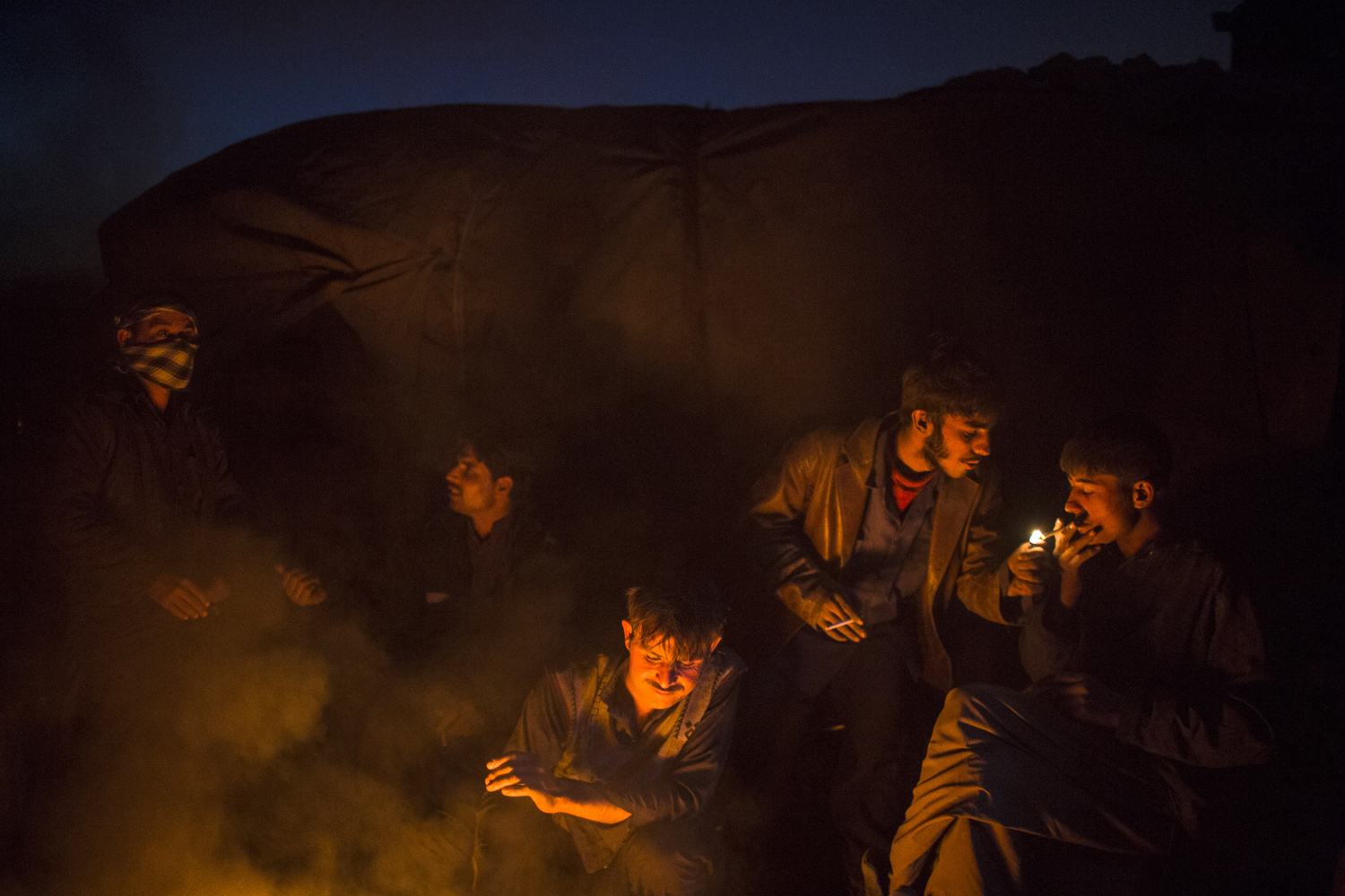 Image: Nov. 14, 2012. Afghan boys sit around a fire after scavenging for recyclables at a garbage dump site in Kabul.