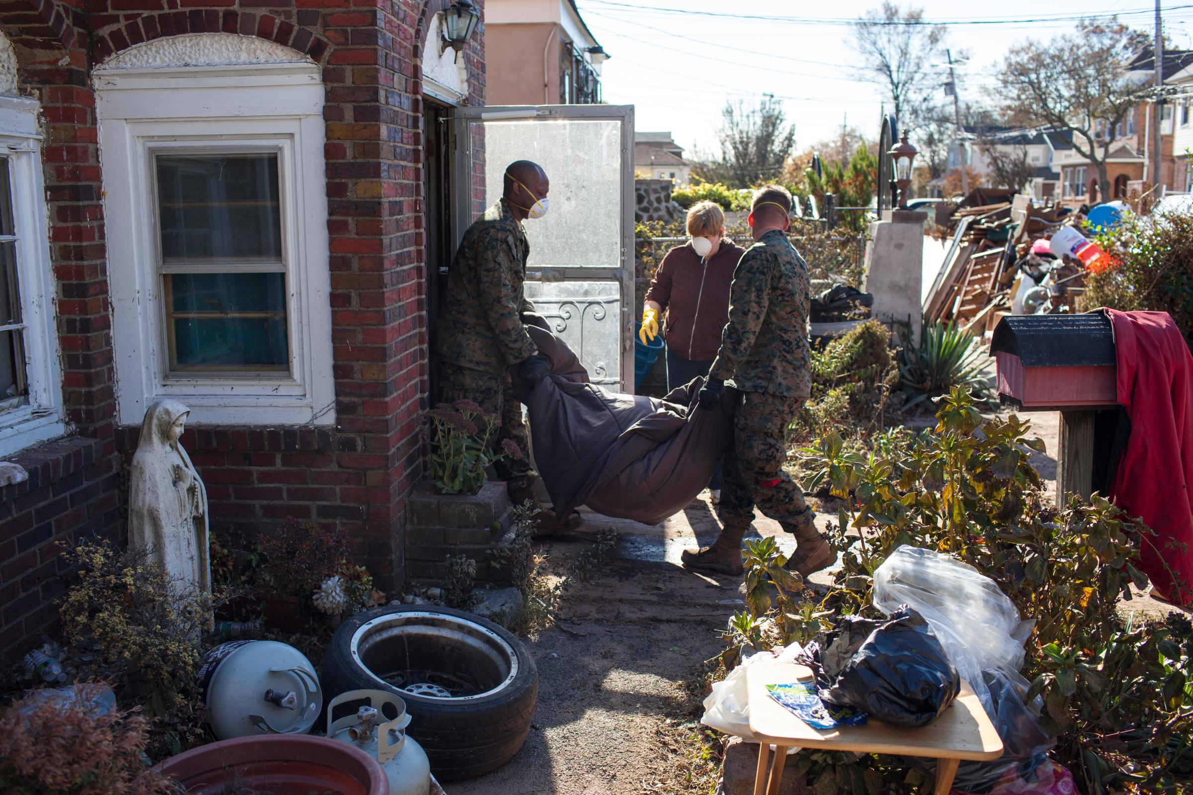 Image: Nov. 6, 2012. U.S. Marines and U.S. Navy seamen offer assistance to local residents removing damaged household items caused by Superstorm Sandy in the New Dorp Beach neighborhood in the Staten Island borough of New York.