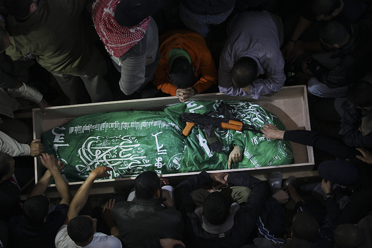 Image: Nov. 15, 2012. Palestinians mourn next to the body of Hamas militant Mohammed al-Hams during his funeral in Gaza City.