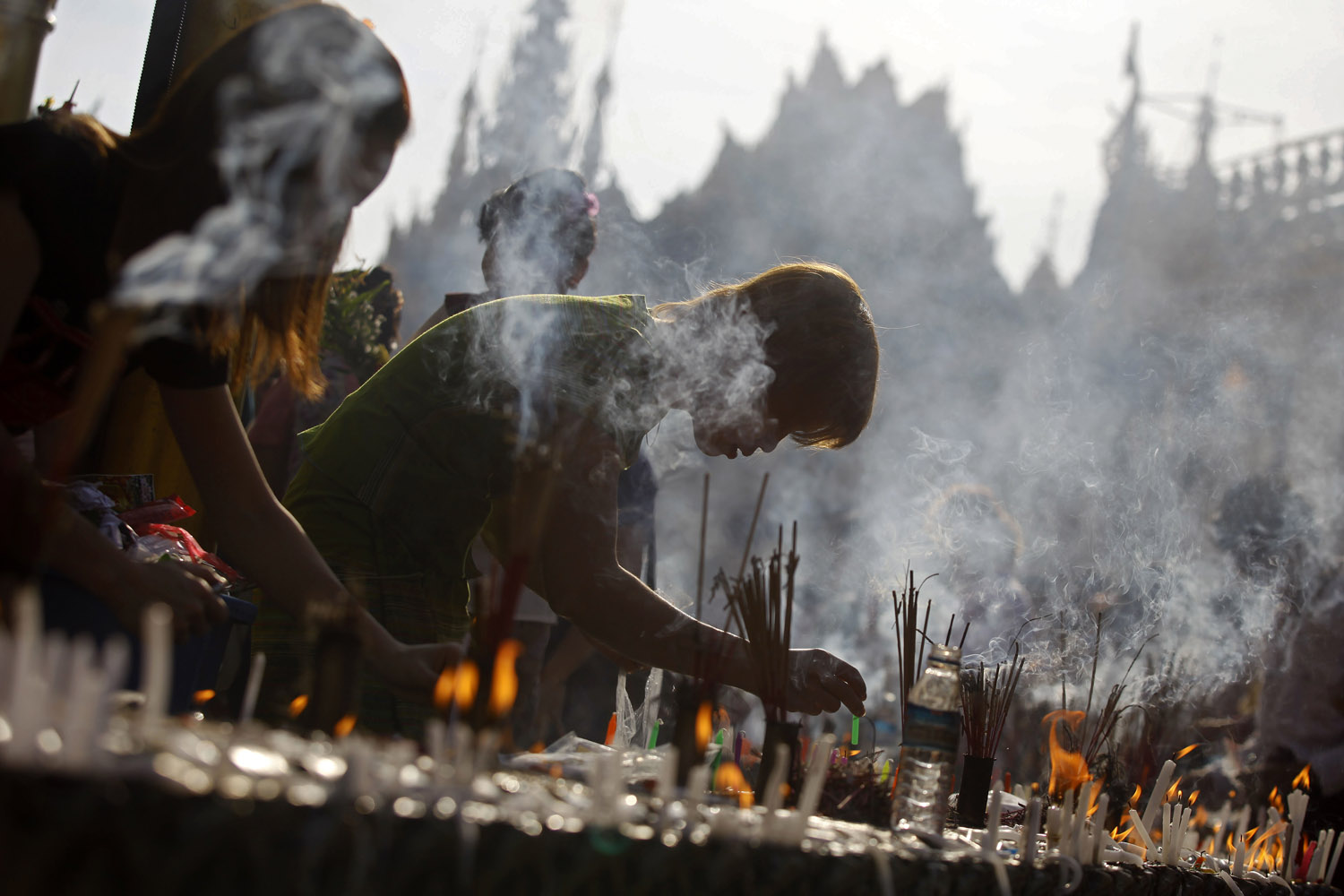 Image: Oct. 30, 2012. People light candles at a pagoda during the Full Moon Festival in Yangon, Myanmar.