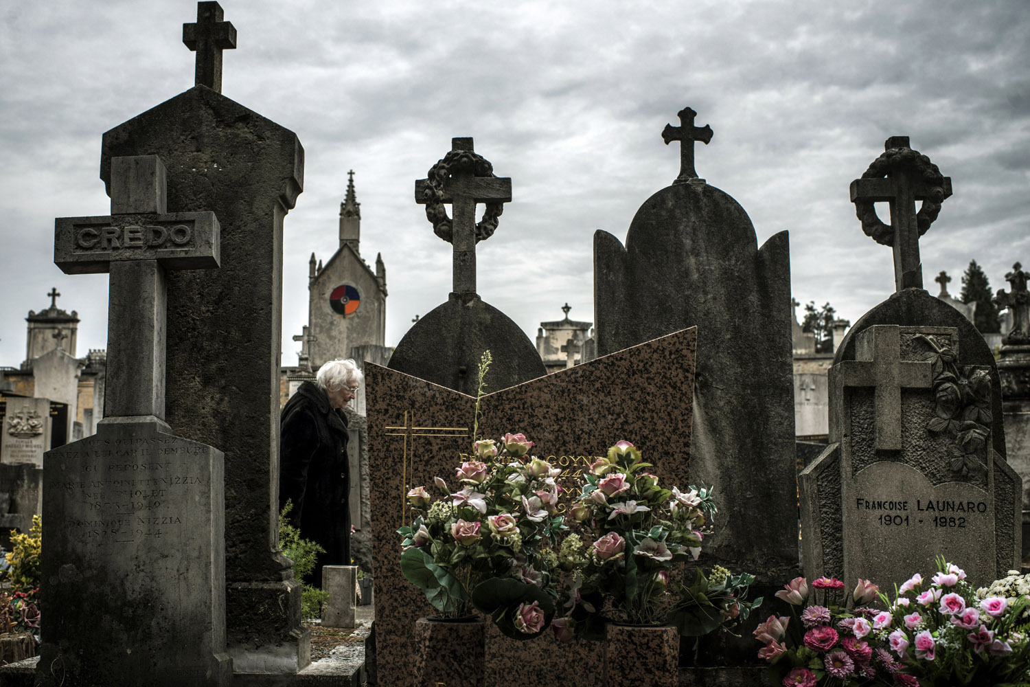 Image: Oct. 31, 2012. A woman stands in front of a tombstone in a cemetery in the central French city of Lyon, on the eve of All-Saints Day.